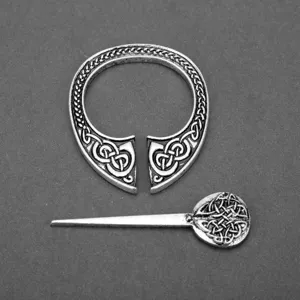 Nahaufnahme einer Viking-Brosche mit keltischen Knotenmustern auf grauem Hintergrund