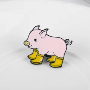 Close-up detail of a cute pink pig enamel brooch pin wearing four yellow rain boots