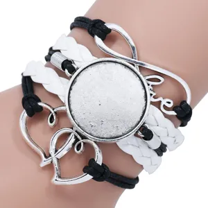 Close-up of handmade multi-layer braided bracelet with blank round gem tray and love charm