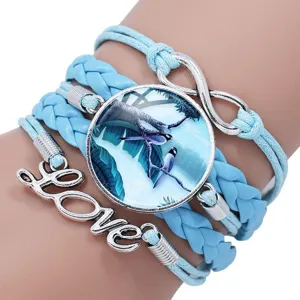 Detailed macro view of light blue handmade braided bracelet with bird time gem and Love charm