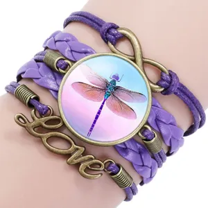 Close-up of purple braided multilayer bracelet with dragonfly glass cabochon and Love charm