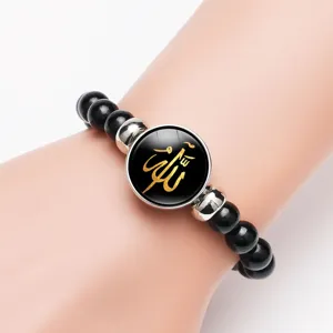 Detail view of Islamic Allah calligraphy pendant bracelet on arm with black beads