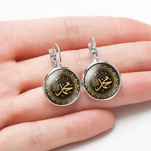 Detailed close-up of silver-tone leverback earrings featuring golden Islamic calligraphy design