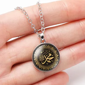 Detail shot of a time gem necklace pendant featuring golden Arabic calligraphy Muhammad.