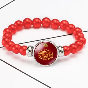 Red beaded elastic bracelet with glass cabochon featuring gold Arabic calligraphy design