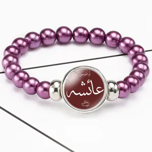 Detailed view of purple pearl elastic bracelet with Arabic Aisha script time gem pendant