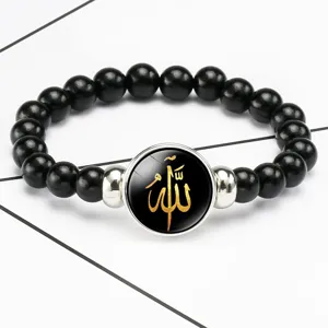 Macro detail of black beaded stretch bracelet with gold Allah Islamic calligraphy