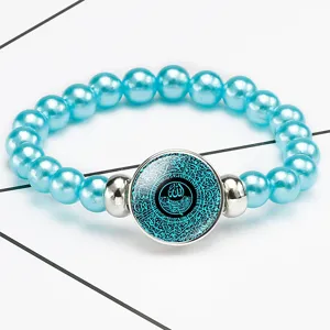 Detail view of a blue beaded stretch bracelet with Islamic Arabic calligraphy design