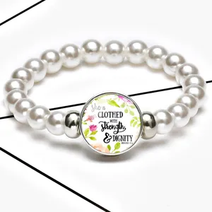 Close-up of stretch pearl bracelet featuring Strength & Dignity time gem pendant