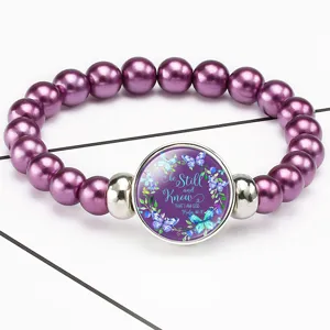 Detailed view of purple bead bracelet with Bible quote Be Still and Know glass gem
