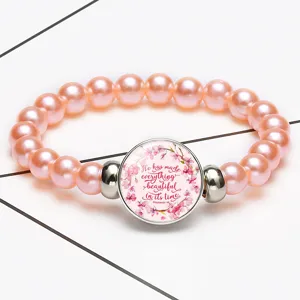 Close-up detail of pink pearl stretch bracelet featuring a biblical quote time gem pendant