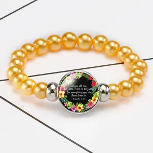 Close-up of golden beaded bracelet with Proverbs 4:23 bible verse glass cabochon
