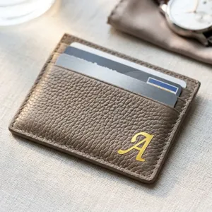 Gros plan d'un autocollant doré lettre 'A' de 0,5 pouce sur un portefeuille en cuir.