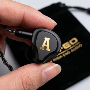 Detailed view of a gold metallic letter A sticker applied on a black earphone shell.