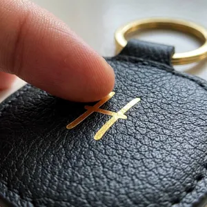 Gros plan d'un autocollant métallique lettre H doré brillant sur du cuir