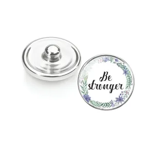 Vue macro détaillée du bouton pression en verre avec couronne de fleurs Be stronger