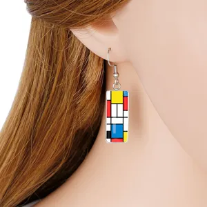 Close-up view of artistic Mondrian-style geometric rectangular earrings on a model