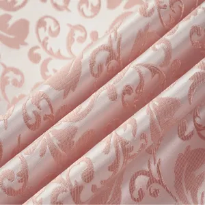 Close-up of pink damask jacquard fabric with elegant floral pattern and satin sheen.