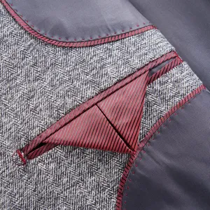Detail view of men's grey tweed suit jacket interior with maroon striped pocket piping