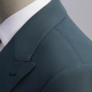 Close-up of slim fit double-breasted teal suit jacket with fine stitching detail