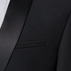 Professional close-up of black men's tuxedo jacket with satin shawl lapel and pocket detail