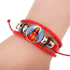 Close-up of red woven leather bracelet with Sacred Heart of Jesus religious charm