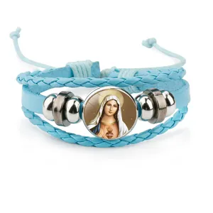 Detail view of a light blue braided leather bracelet with a Virgin Mary glass charm.