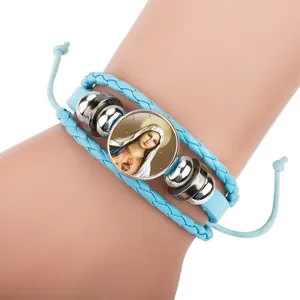 Detail view of light blue braided cowhide bracelet with Virgin Mary glass charm
