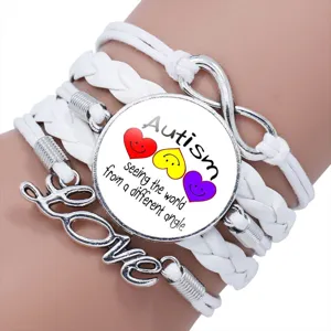 Close-up of white multi-layer braided Autism awareness bracelet with Love charm.