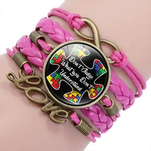 Detailed view of pink multi-layer autism awareness bracelet with puzzle piece charm