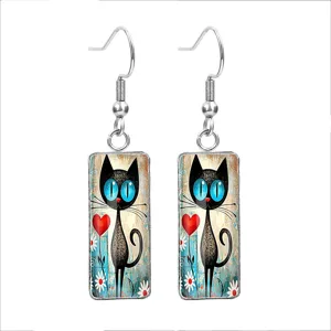 Detailed view of rectangular glass earrings with cute black cat and heart illustration