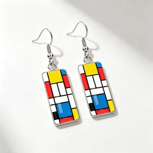 Close-up of artistic Mondrian style geometric earrings with red blue and yellow patterns