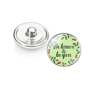 Vue détaillée d'un bouton pression en verre avec fleurs et citation inspirante