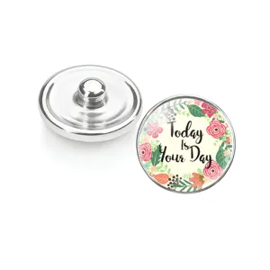 Vue détaillée d'un bouton pression en verre avec un motif floral inspirant 'Today Is Your Day'