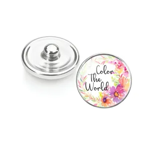 Gros plan de boutons pression en verre avec motif floral et texte Color The World.