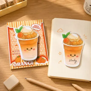 Detalle de una linda nota adhesiva de dibujo animado de bebida naranja en un cuaderno abierto