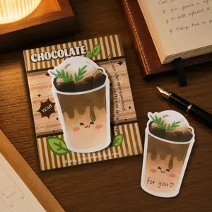 Primer plano de notas adhesivas con tema de chocolate en un acogedor escritorio de madera