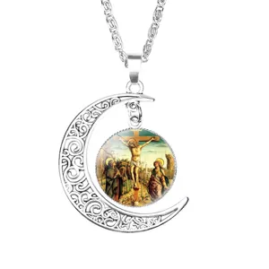 Detail of a silver crescent moon necklace featuring a religious crucifixion painting