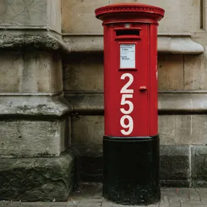 Close-up of 4-inch glitter white vinyl number stickers applied to a red mailbox surface