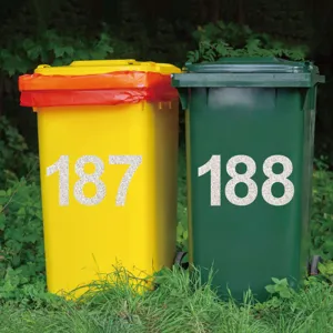 Detail view showing the 4 inch silver glitter vinyl number stickers applied on outdoor trash bins