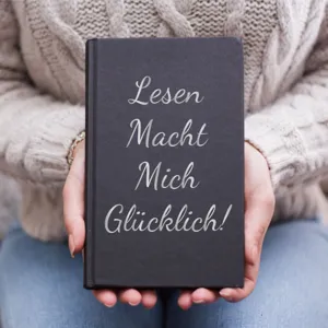 Close-up view of DIY German alphabet stickers applied to a black notebook cover