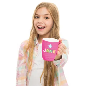 Close-up of colorful alphabet stickers forming 'JANE' on a child's pink mug