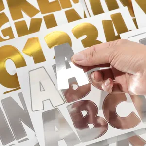 Close-up of a hand holding a 3-inch reflective silver metallic letter A sticker