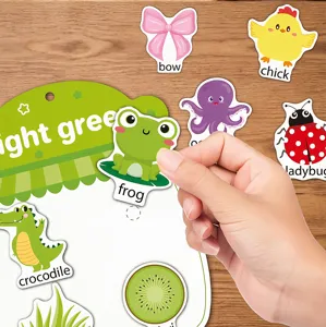 Detailansicht einer Hand, die einen Froschaufkleber in ein Lern-Stickerbuch klebt