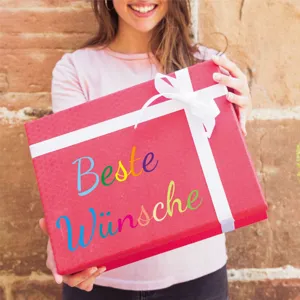 Detailed view of colorful German letter stickers applied on a red gift box for DIY gifting
