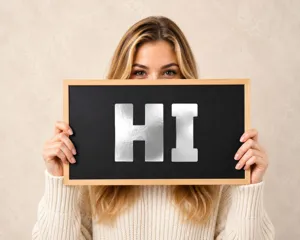 Detailed shot of 3-inch bright silver metallic letter stickers 'HI' on a blackboard.