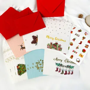 Close-up of gold-stamped Christmas card set with red envelopes and festive stickers