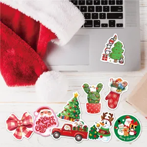 Vibrant cartoon Christmas stickers displayed on white wooden surface near a laptop