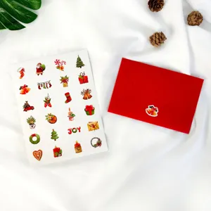 Detailed view of Christmas sticker sheet and red envelope with pine cone decor