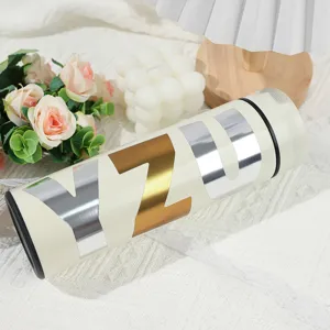 Close-up of 3-inch shiny gold and silver metallic letter stickers on a thermos